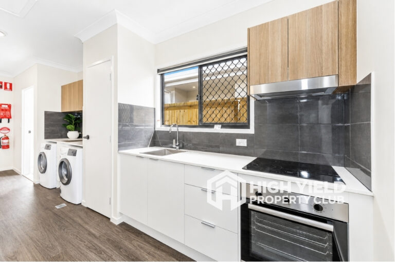 Common area with laundry and kitchen in a modern rooming house in Moreton Bay