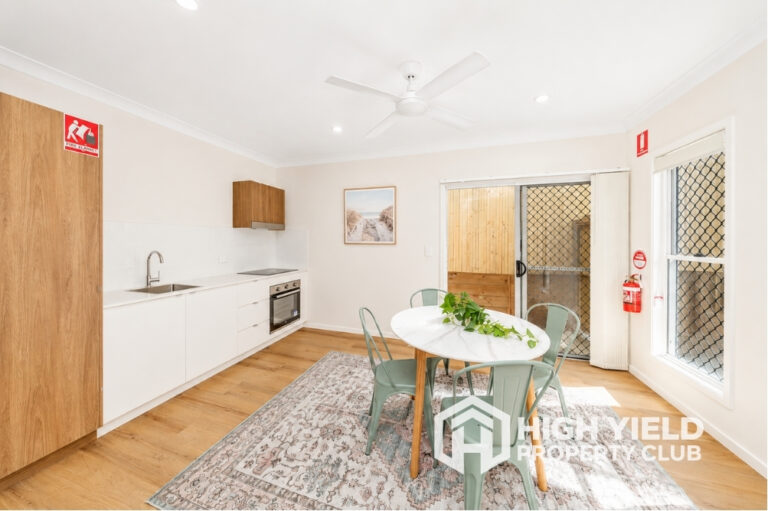 spacious common area with kitchen and dining in a modern rooming house